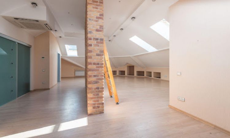 Wooden attic ladder placed in a room with sun coming through the windows